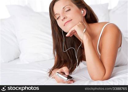 Young woman listening to music holding mp3 player with ear buds