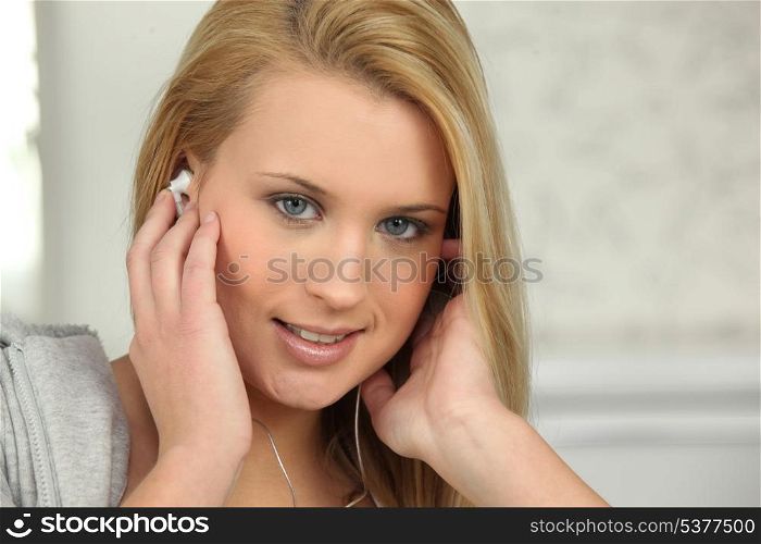 Young woman listening to music on earphones