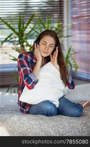 Young woman listening to music on sofa at home