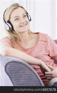 Young Woman Listening To Music On Wireless Headphones