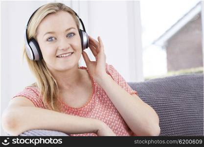 Young Woman Listening To Music On Wireless Headphones