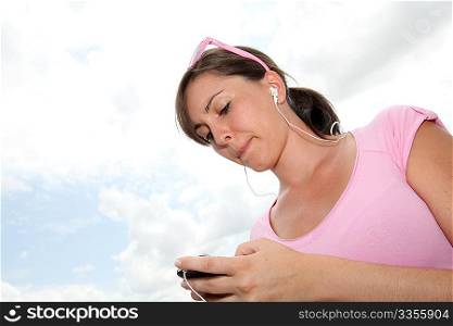 Young woman listening to music player