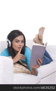 Young woman listening to music while reading