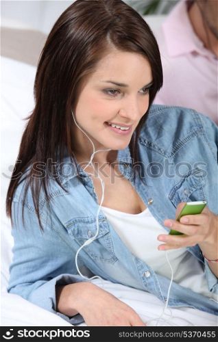 Young woman listening to music with mp3 player