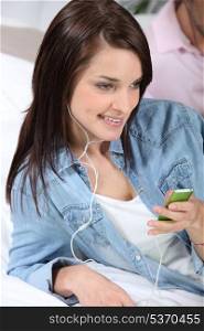 Young woman listening to music with mp3 player