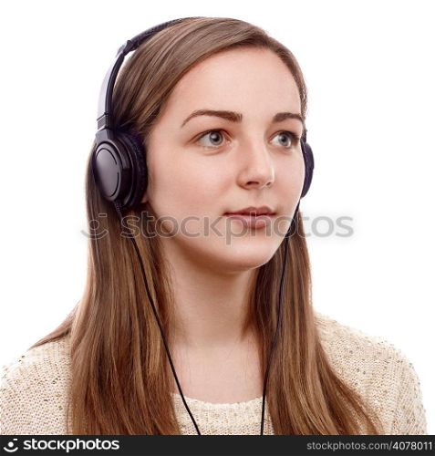 Young woman listening to the music on headphones