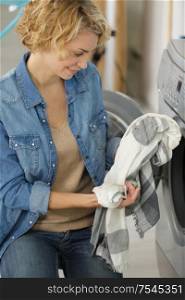 young woman loading washing machine
