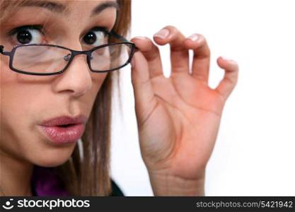 young woman looked amazed, she&rsquo;s lowering her glasses