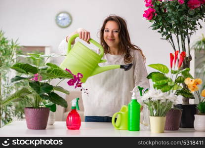 Young woman looking after plants at home