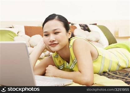 Young woman looking at a laptop and thinking