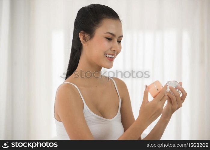 Young Woman Looking At Beauty Product While Sitting At Home