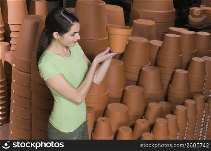 Young woman looking at flower pot in a garden center