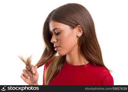 Young woman looking at her hair isolated over white