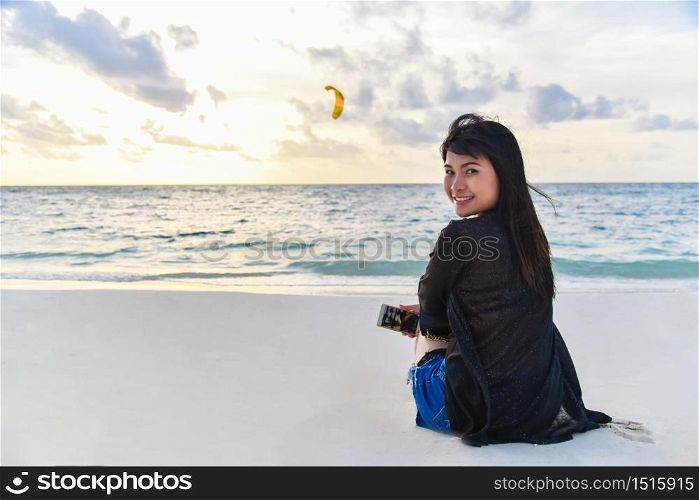 Young woman looking at the camera on the beach.