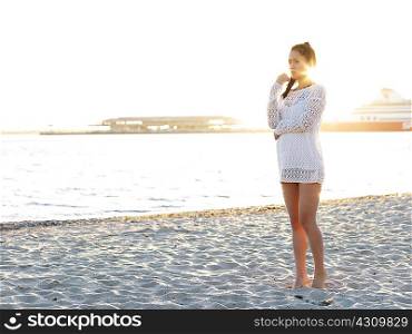 Young woman looking away on sunlit beach, Port Melbourne, Melbourne, Victoria, Australia