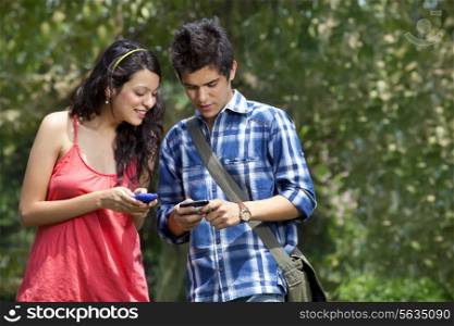 Young woman looking in friends mobile phone