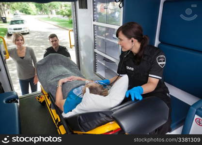 Young woman looking into ambulance at senior woman