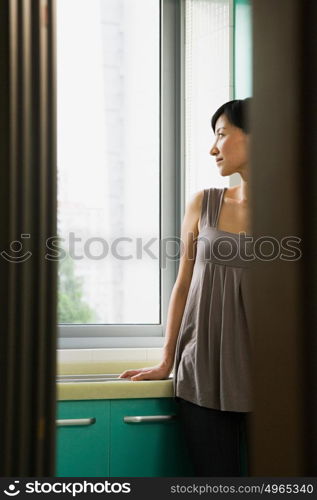 Young woman looking out of a window