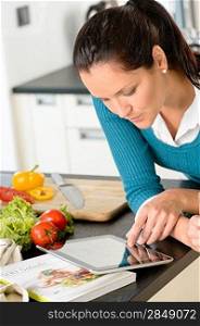 Young woman looking tablet recipe kitchen vegetables preparing food