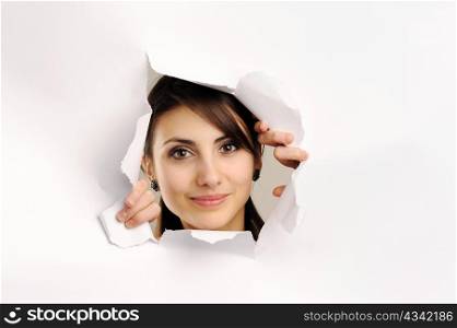 Young woman looking through hole in paper