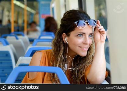 Young woman looking through the window in a train. Business people.