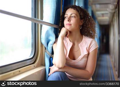 young woman looks in train`s window