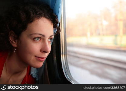 young woman looks in train`s window