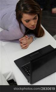 young woman lying and laptop