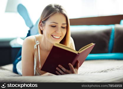 Young woman lying and reading