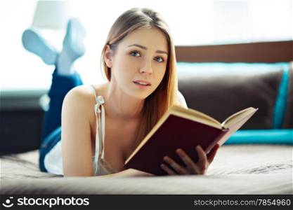 Young woman lying and reading