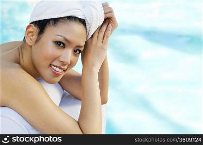 Young woman lying by swimming pool, portrait