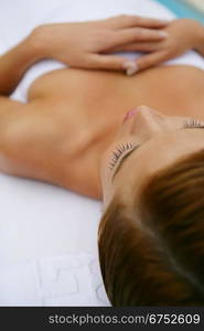 Young woman lying down in a white towel