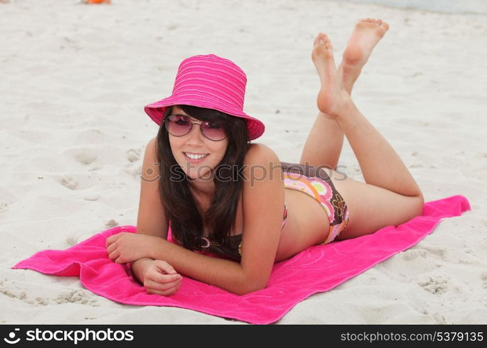 young woman lying down on the beach