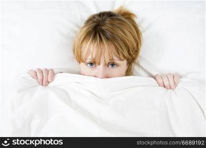 Young woman lying in bed doesn&acute;t want to wake up