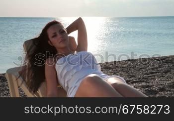 young woman lying on a beach at sunset