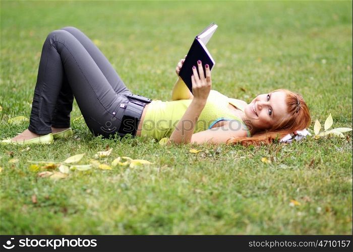 Young woman lying on a carpet of leaves in autumn park