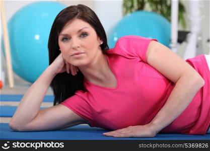 Young woman lying on an exercise mat