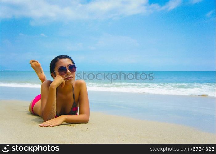 Young woman lying on beach sun tanning.