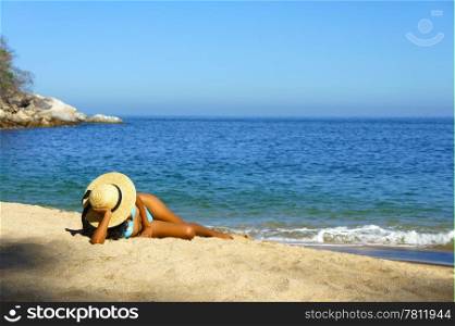 Young woman lying on beach sun tanning.