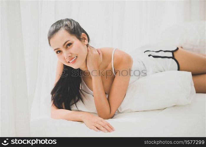 Young Woman Lying On Bed At Home .