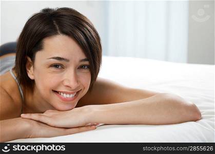 Young woman lying on bed portrait