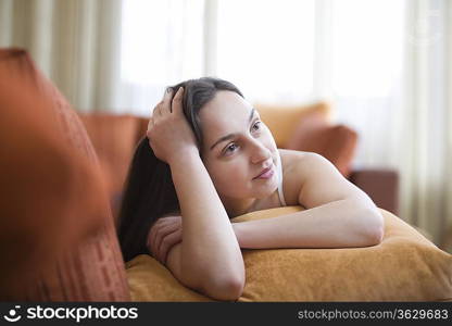 Young woman lying on sofa, portrait