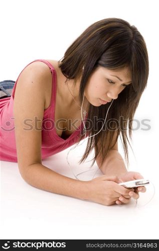 Young woman lying on the floor and listening to an MP3 player