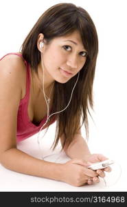 Young woman lying on the floor and listening to an MP3 player