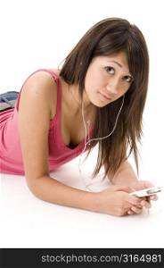 Young woman lying on the floor and listening to an MP3 player
