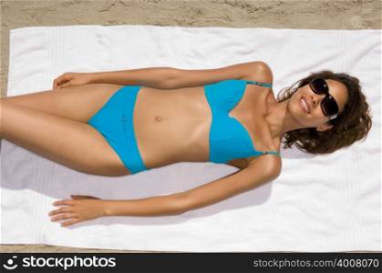 Young woman lying on towel