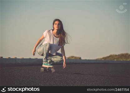 Young woman makign a downhill with her skateboard