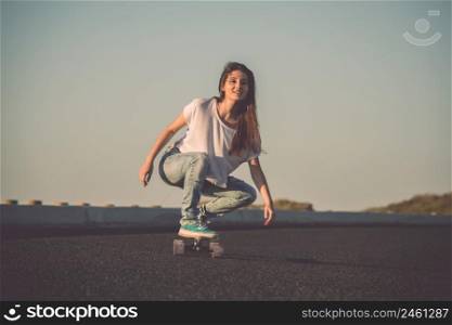 Young woman makign a downhill with her skateboard