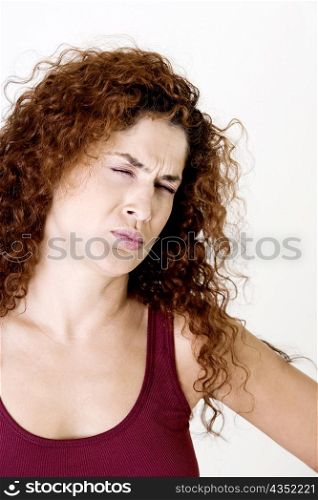 Young woman making a face with her eyes closed