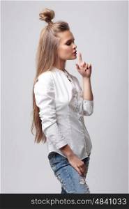 Young woman making a hand sign silence. Secret. Teen fashion.